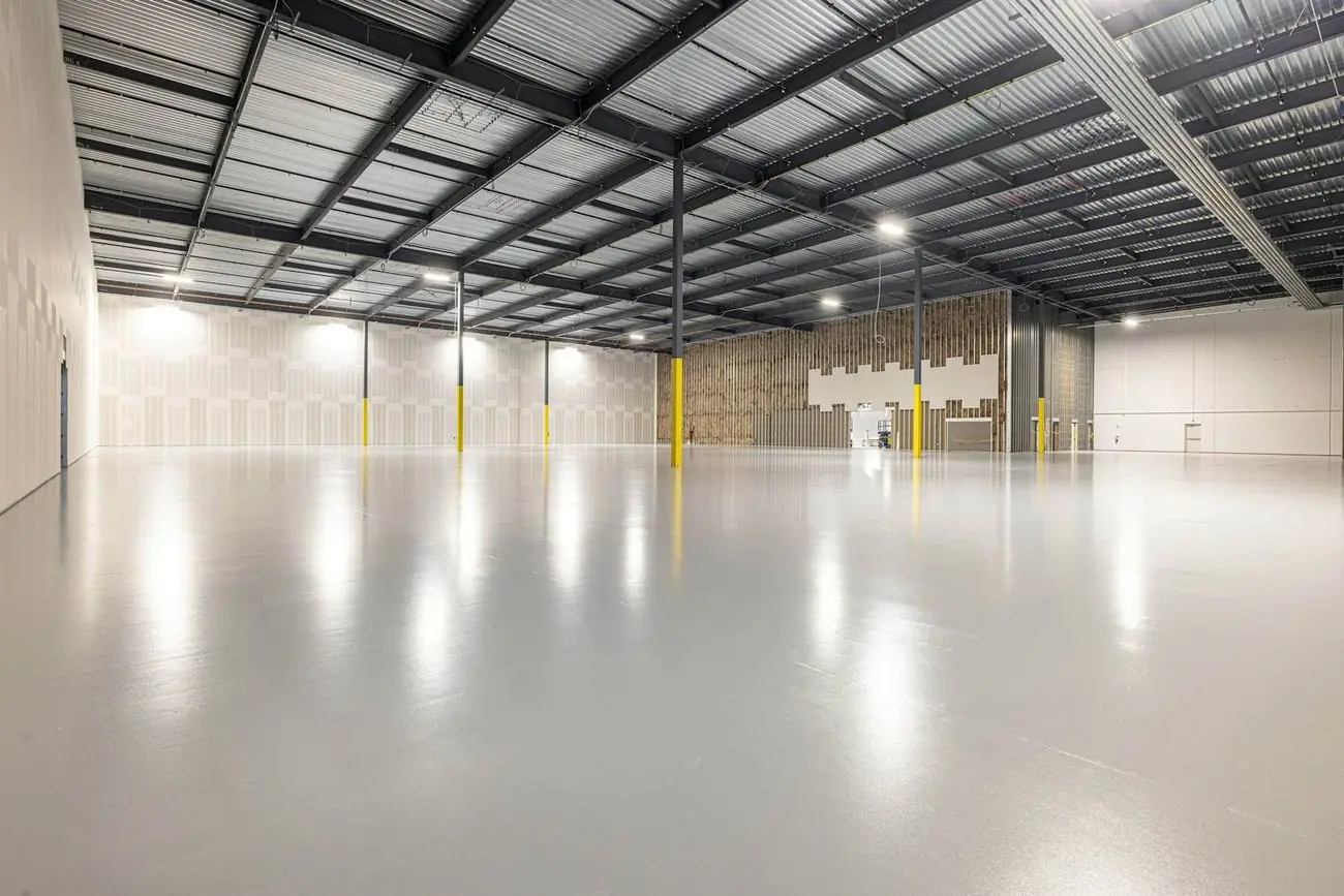 Nave industrial amplia con piso pulido y techo alto