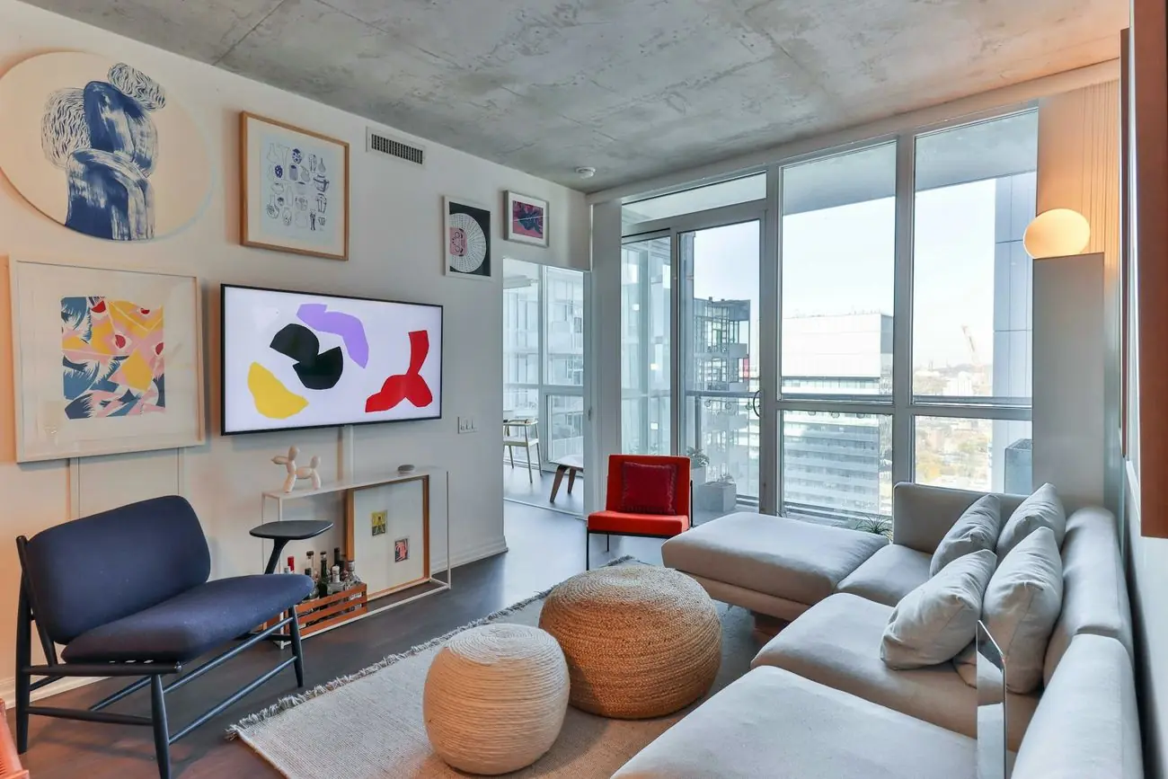 Sala de un apartamento moderno con ventanales y vista a la ciudad